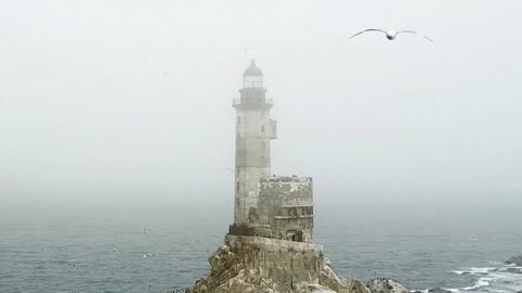 A Shot of an Old Lighthouse by the Rocky Coastal Area