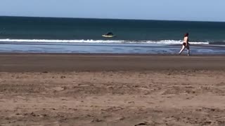 Surfer in the distance does push ups on his surfboard while on the water