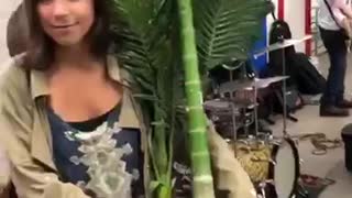 Woman dancing with potted plant in subway to live music