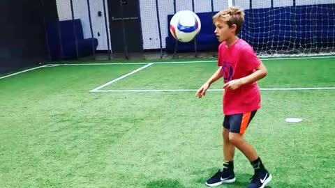 Young soccer star makes trick shot off wall