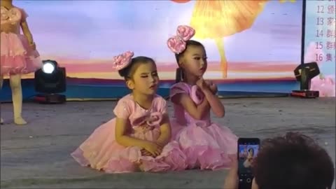 Audience in hysterics as little girl falls asleep during dance performance