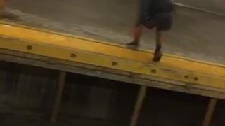 Guy jumps across subway train tracks and makes it to other side
