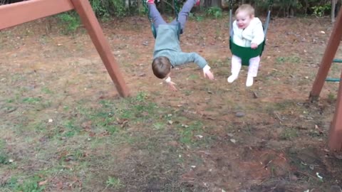 Brother Falls Off Swing In Slow Motion While Baby Sister Rides Next To Him