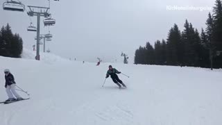 Woman skiing black jacket with green falls in front of camera