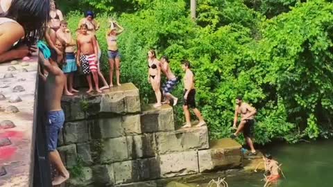Guy back flip off bridge belly flop lake river water