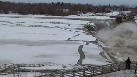 Warming river breaks apart ice, sends it over waterfall edge