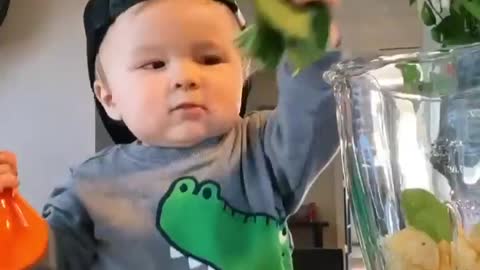 Cute baby make a fruit juice