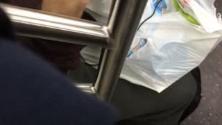 Person on subway train eating skippy peanut butter with their finger