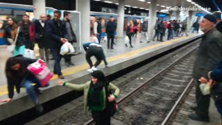 People running across train tracks