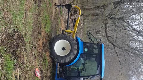 tractor digging holes with a post hole digger