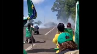 People kneel in prayer as police fire gas bombs Brazil