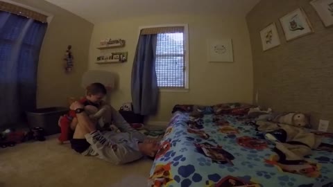 Father flips son backwards onto bed in slow motion