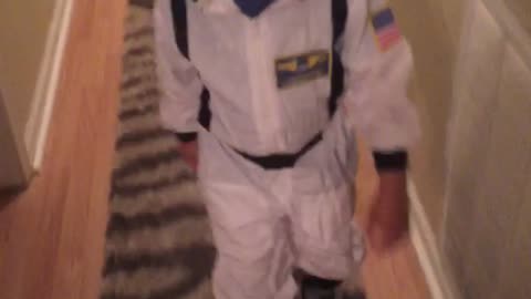 Tot learning to skate in astronaut costume