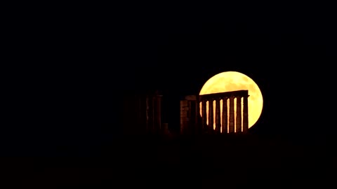 'Strawberry Moon' rises behind ancient Greek temple
