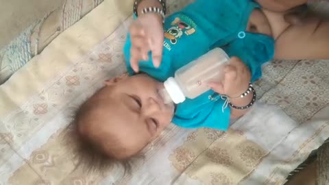 Cute boy playing with milk bottle