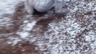 Girl slides down playground slide in the snow and falls on her butt