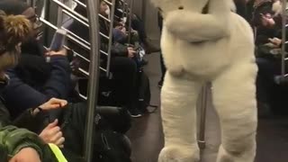 Person in large white bear costume on subway