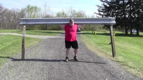 Strongman Steve McGranahan carries heavy guardrail on his shoulders