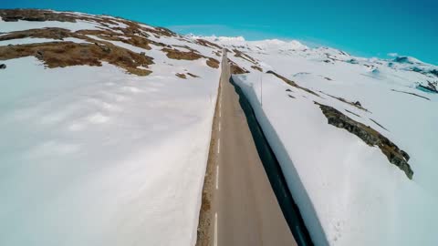 mountain road in norway with high snow wall