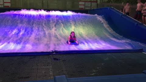 Young girl braves surf simulator, wipes out instantly!