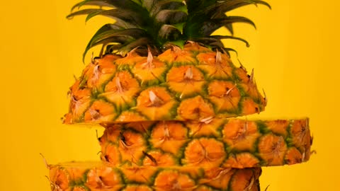 Pineapple sliced on a yellow background