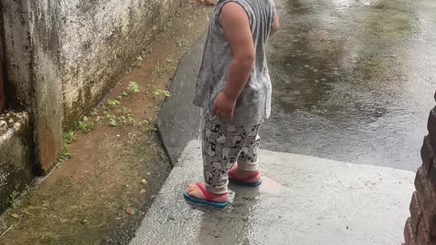 Boy Splashes In Rain Gutter Runoff