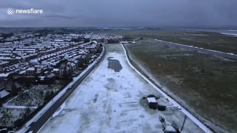 Stunning drone footage of rare snow-covered shoreline on the English coast