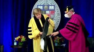 Merkel wrestles with robes at degree ceremony