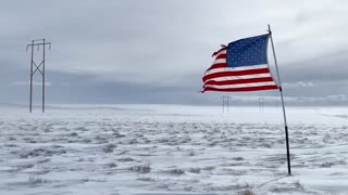 American Flag Blowing in Freezing Landscape