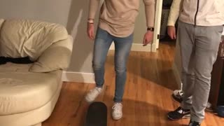 Brown shirt guy living room falls off skateboard