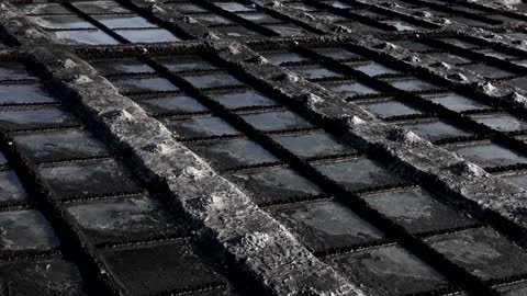 Volcanic ash darkens La Palma's pristine salt flats