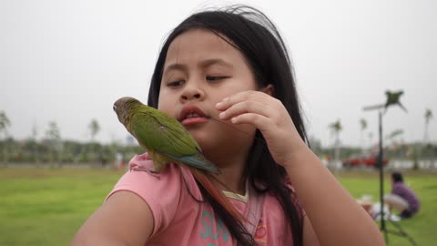 A Girl Holding A Parrot