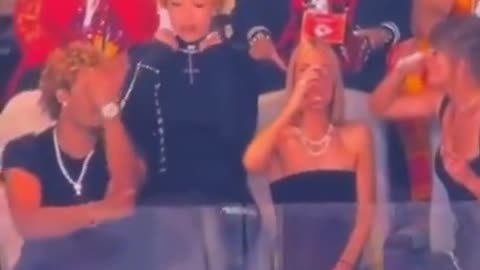 Taylor Swift's guest Ice Spice DEMONIC SIGN gestures while wearing upside down Cross at Super Bowl.