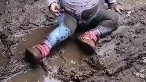 The child really enjoys playing in the mud