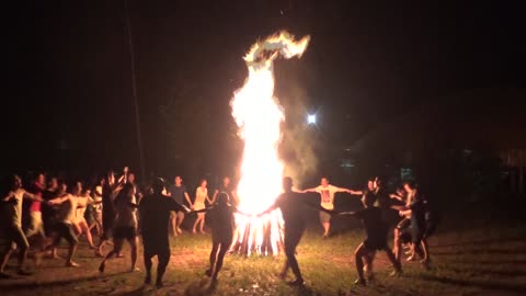 Funny dancing around big fire in Vietnamese forest