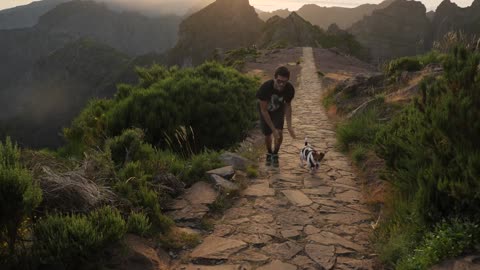 Man Running with a Dog on Mountain Top