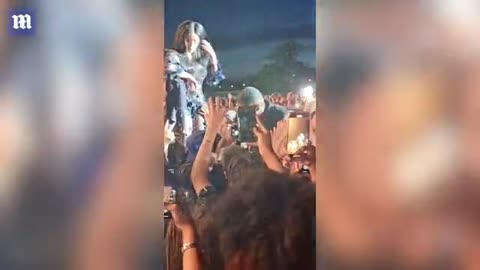 Cardi B appears to hit fan with her microphone while raucous crowd cheers her on in new footage