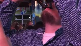 Guy in blue shirt drinking beer