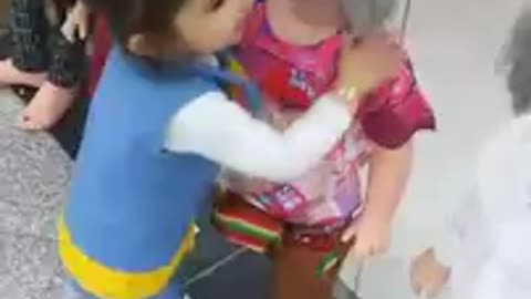 Adorable girl speaking to dolls in toys store