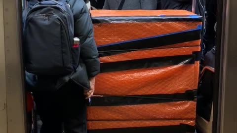 Giant orange boxes bags in subway door path