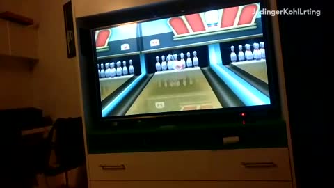Guy green shirt slips while wii bowling strike