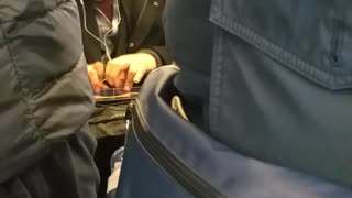 Man plays guitar on his ipad on subway
