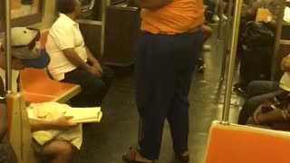 Girl orange shirt dancing on pole subway