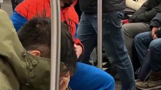 Guy in spiderman suit stretches legs on subway train