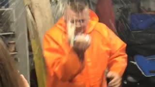 Music guy in orange jacket cracks beer over head and chugs in a garage