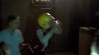 Guy with yellow helmet cracks beer over it and chugs it