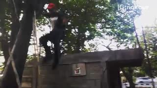 Guy in red hat jumps off roof lands on dirt