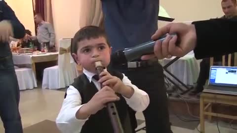 Five year old boy playing on the Armenian musical instrument