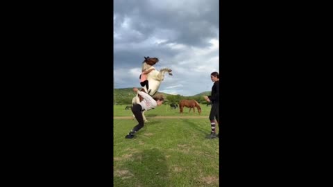 Horse majestically jumps simultaneously with girl's backflip