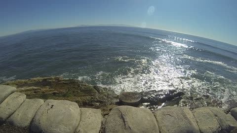 Santa Cruz, man made water spout shoots up as waves approach.